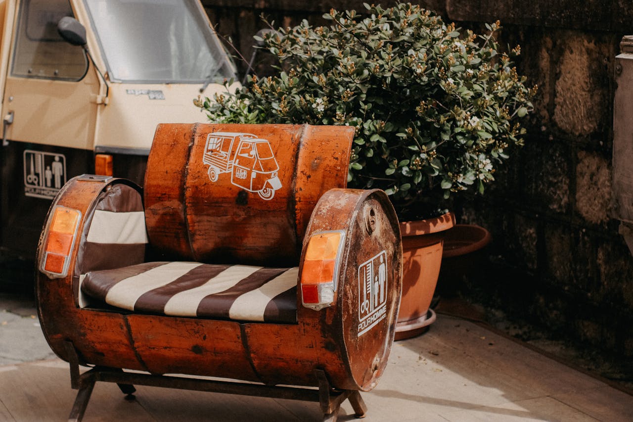 Crafting Captivating Headlines: Your awesome post title goes here Creative urban armchair made from a recycled barrel and vintage scooter details next to a potted plant.