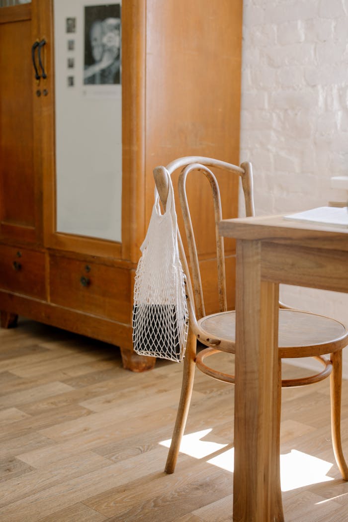 our-story A cozy wooden chair and table in a minimalist apartment with natural light.