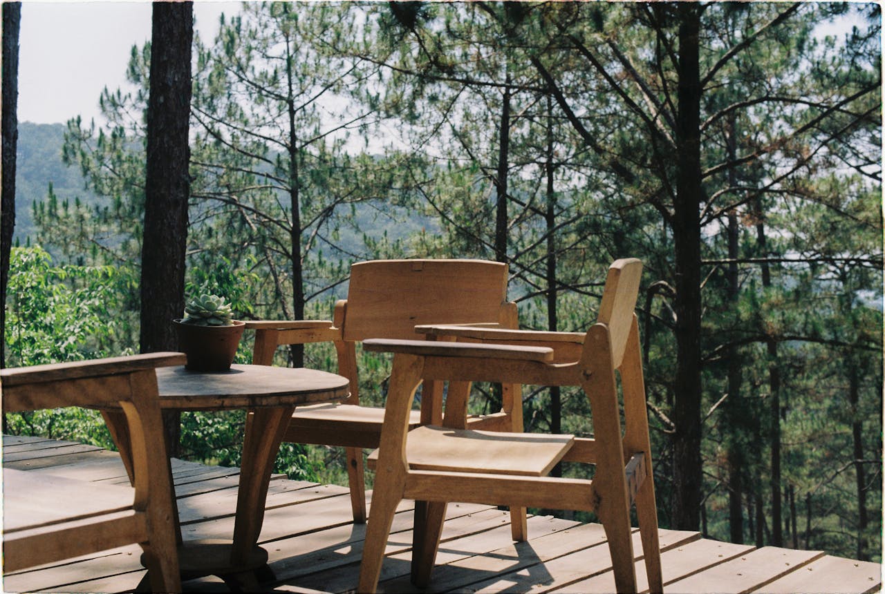 The Art of Drawing Readers In: Your attractive post title goes here Wooden patio with chairs and table overlooking a lush forest, perfect for relaxation.